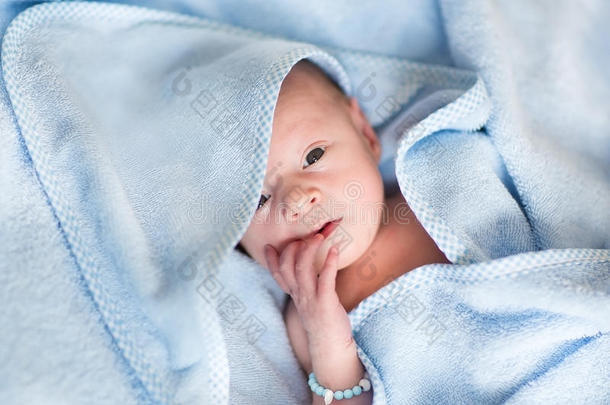 刚出生的婴儿在洗完澡后用蓝色毛巾放松