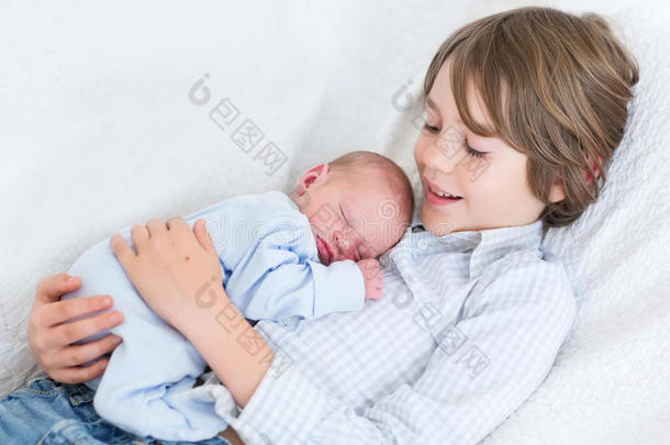 快乐的笑男孩抱着他熟睡的新生弟弟