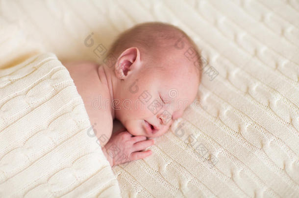 小婴儿躺在柔软的针织毯子上