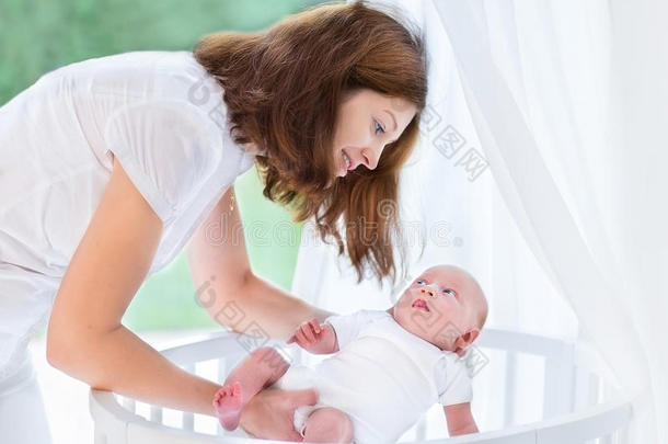 年轻母亲把刚出生的婴儿放进婴儿床