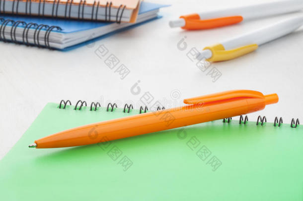 橙色塑料圆珠笔配绿色笔记本