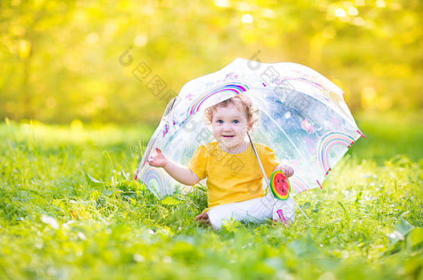 可爱有趣的小女孩在雨中<strong>伞下</strong>玩耍