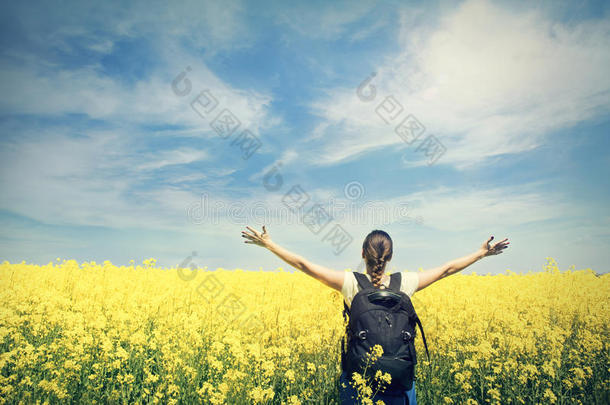黄色<strong>田野上</strong>背着背包的年轻快乐的女人