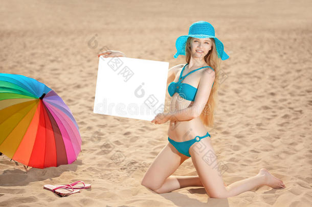 海滩上举着白色空白海报的女人