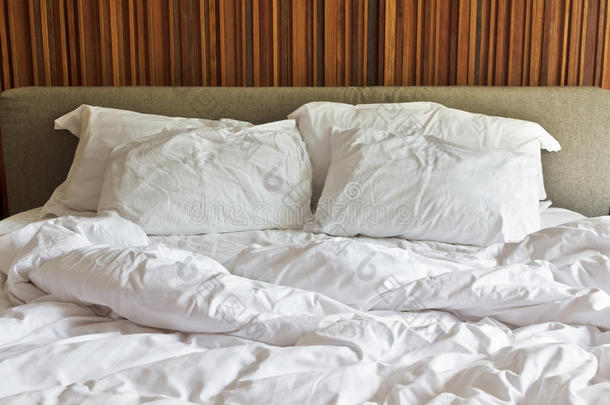 凌乱的白色床和两个枕头