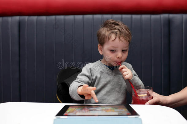 孩子喝果汁玩电脑