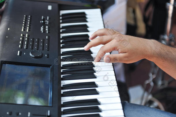 一只手在钢琴键盘上弹奏的特写细节