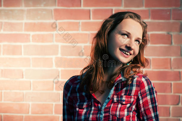 姜发女孩背着红砖墙在户外摆造型，目光移开，临摹空间很大
