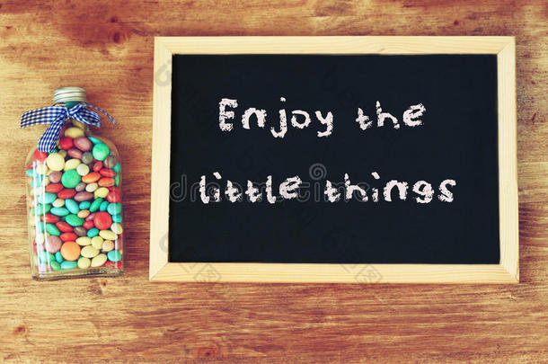 装满糖果的瓶子和黑板上写着“享受<strong>小东西</strong>”。
