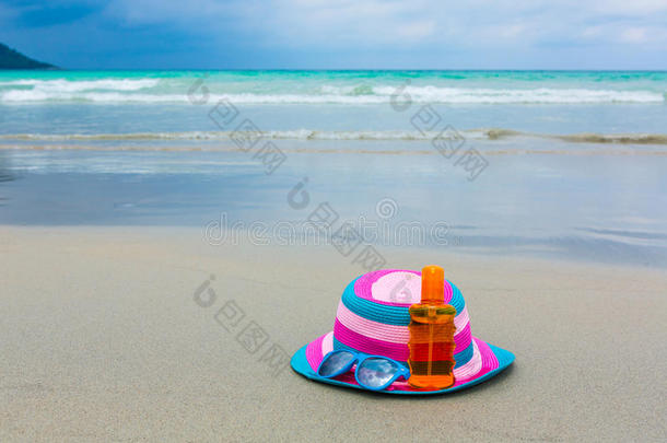 夏天在海滩上涂防晒霜和戴帽子的墨镜
