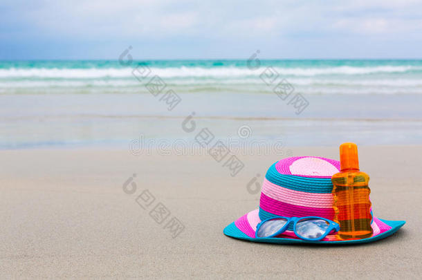 夏天在海滩上涂防晒霜和戴帽子的墨镜