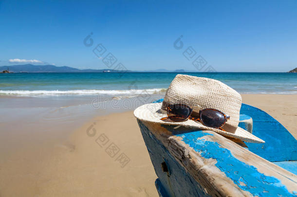 沙滩上的船上戴着帽子和太阳镜