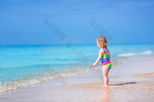 可爱的小女孩在沙滩上奔跑