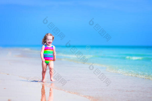 在海滩上奔跑的美丽小女孩
