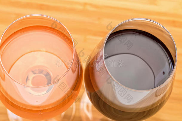 木桌上摆着一杯红色和粉红色的葡萄酒