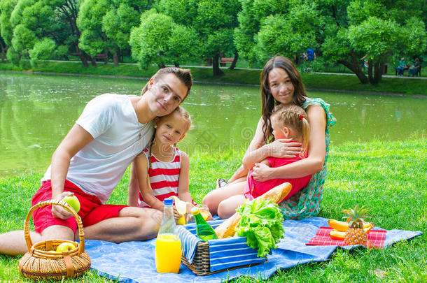 快乐的年轻一家人在户外野餐