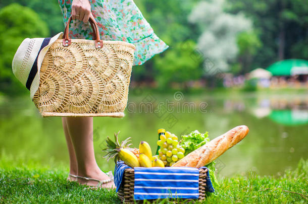 野餐篮子里放着水果、面包和草帽