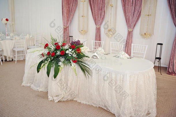 桌上摆着一束美丽的玫瑰花。婚礼上的一束红玫瑰。餐厅餐桌上摆着优雅的婚礼花束