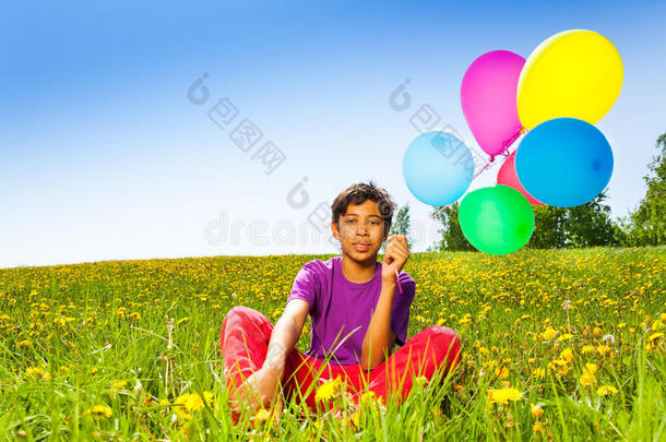 夏天坐着的男孩带着飞气球