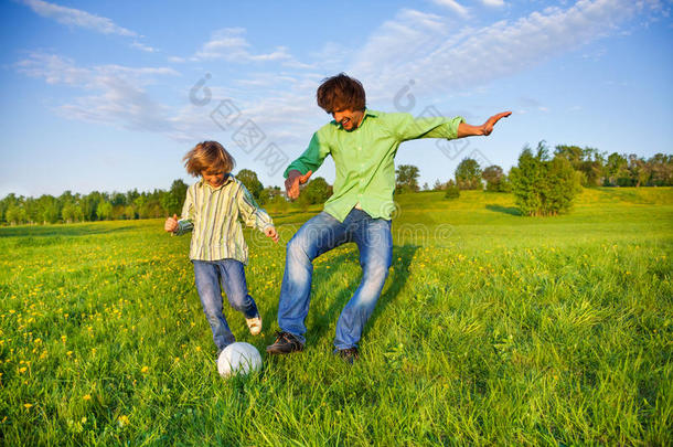 父亲和男孩在公园里一起踢足球