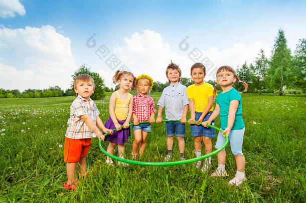 六个有趣的孩子一起拿着一个铁环