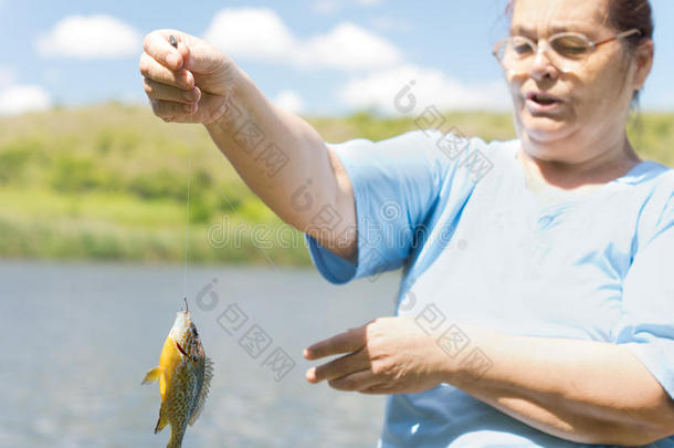 举着一条鱼的中年妇女