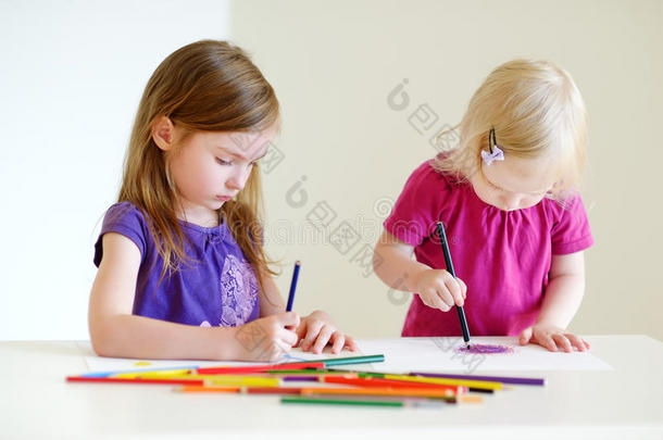 两个<strong>小姐妹</strong>用彩色铅笔画画