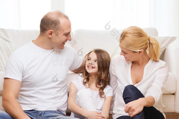 父母和小女孩坐在家里的地板上