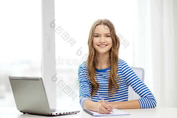微笑的少女笔记本电脑和笔记本