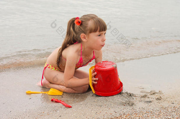 在海边玩沙子的女孩