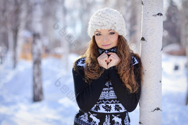 戴白帽子的漂亮女孩站在桦树旁边