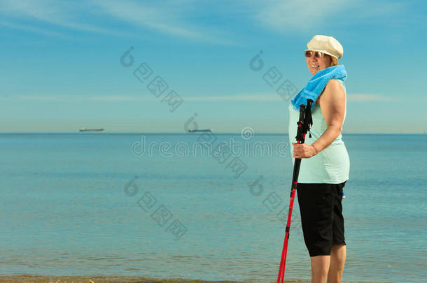 活跃的<strong>女</strong>高级北欧人在海滩上散步