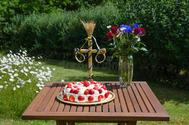 花园里装饰好的桌子上放着自制的<strong>草莓蛋糕</strong>