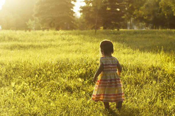 夕阳下在草地上奔跑的小女孩