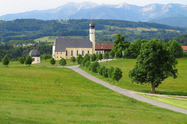 春天，阿尔卑斯山脚下绿草如茵的教堂