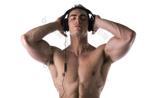肌肉发达的男人赤膊上阵，戴着耳机听音乐