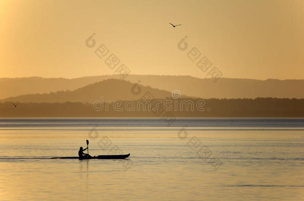 日落时在湖边划皮划艇