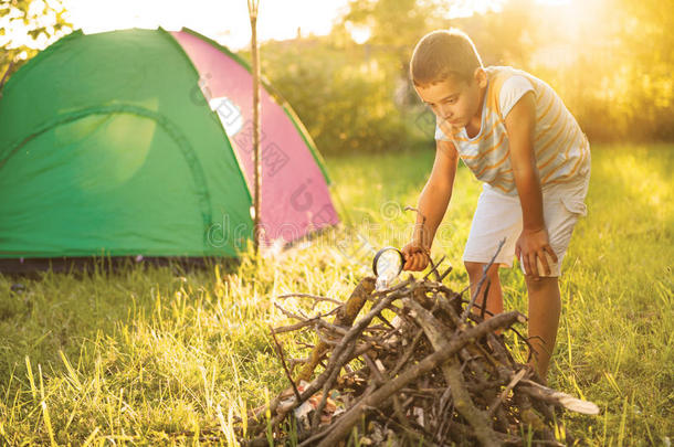 在帐篷里露营-孩子在露营时用放大镜