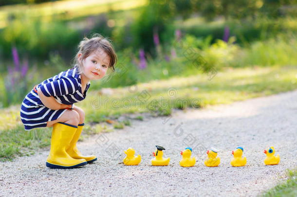 可爱的小女孩和橡胶鸭子在夏季公园