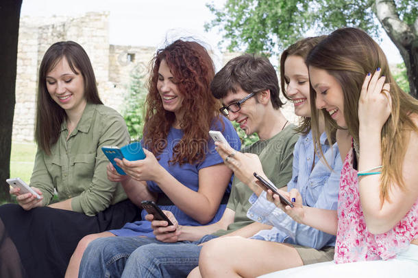 一群快乐的年轻大学生在看手机