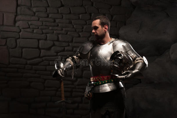 中世纪骑士在黑暗的石头中摆出剑的姿势