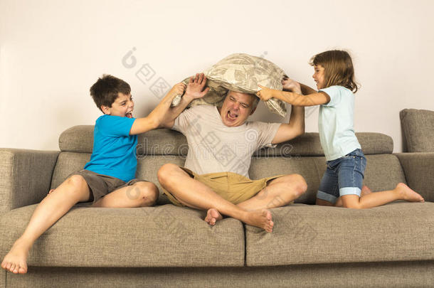 爸爸和孩子们一起用枕头打架