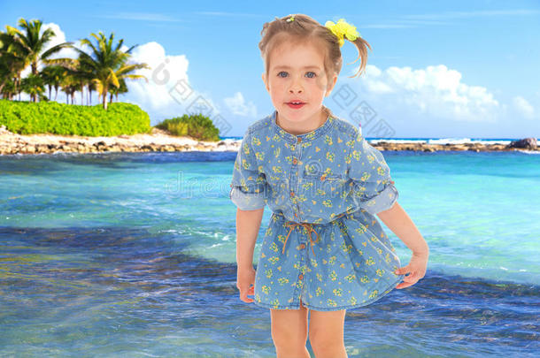 一个穿着蓝色短裙的小女孩，背景是大海。
