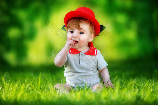 快乐的小宝宝戴着红帽子在太阳林的公园里玩得开心。<strong>暑假</strong>概念。情感。