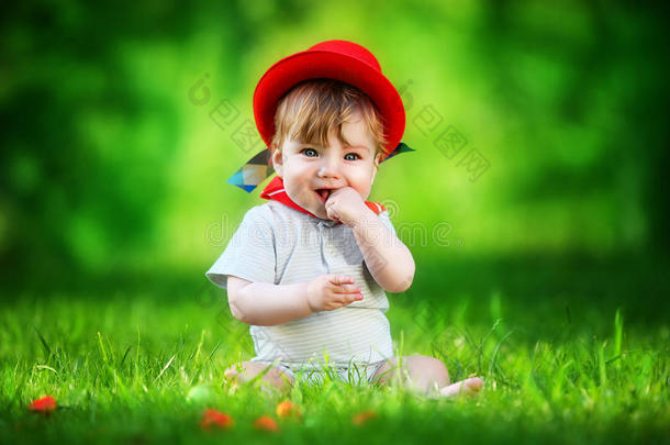 快乐的小宝宝戴着红帽子在太阳林的公园里玩得开心。暑假概念。情感。