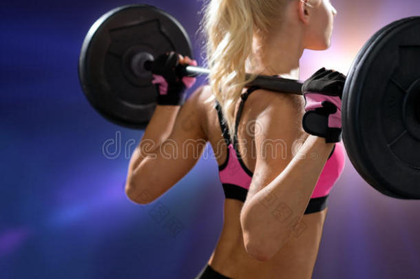 从背后用杠铃锻炼的运动型妇女