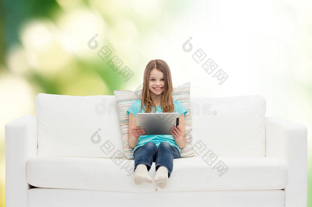小女孩<strong>坐在沙发</strong>上用平板电脑