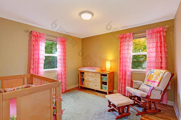 带粉红色褶边窗帘的育婴室