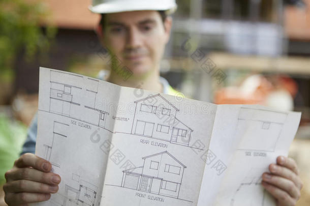建筑工地上的建筑工人正在<strong>看房</strong>屋平面图