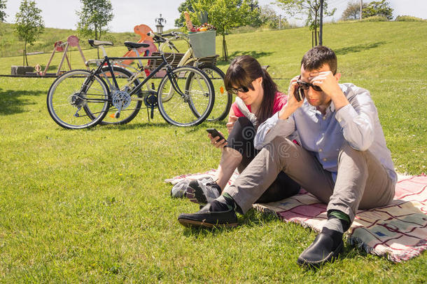 恋爱中的情侣在公园里用智能手机